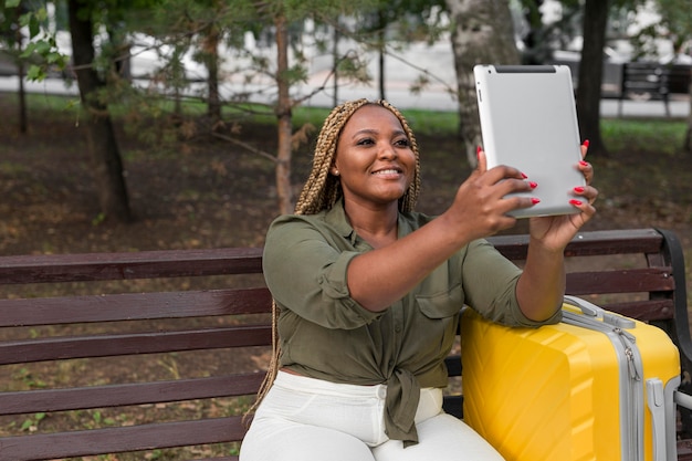 Foto mujer tomando un selfie con su tableta fuera