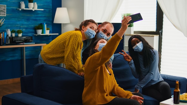 Mujer tomando una selfie con sus amigos por teléfono móvil