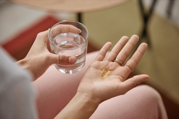 Mujer tomando vitaminas en casa de cerca