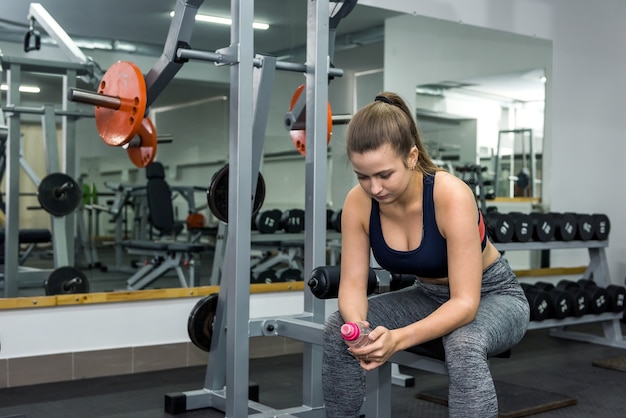 La mujer se tomará un descanso en el gimnasio.