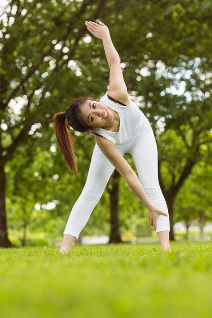 Mujer tonificada haciendo ejercicios de estiramiento en el parque