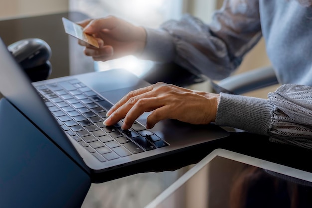 Foto la mujer trabaja en una computadora portátil y usa un teléfono móvil