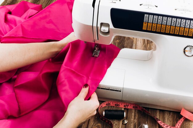 La mujer trabaja en la máquina de coser