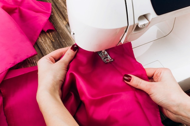 La mujer trabaja en la máquina de coser