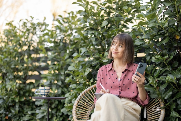 Mujer trabaja en teléfonos inteligentes y tabletas digitales al aire libre