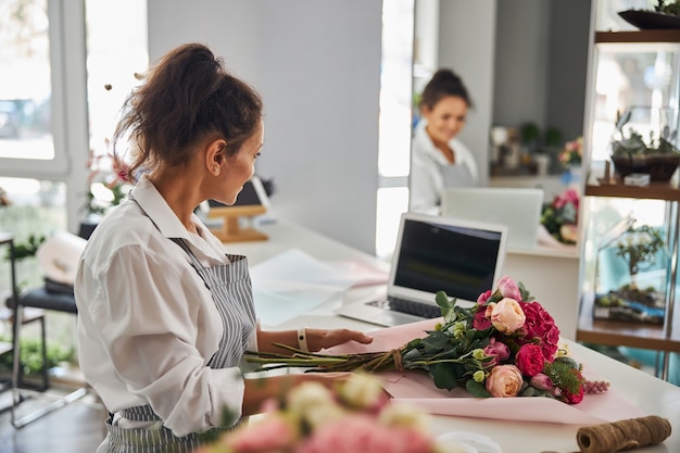 Mujer trabajadora haciendo un elegante ramo presentable