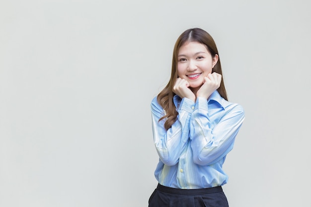 Mujer trabajadora de negocios asiáticos con cabello largo que usa una camisa de manga larga azul sonríe feliz