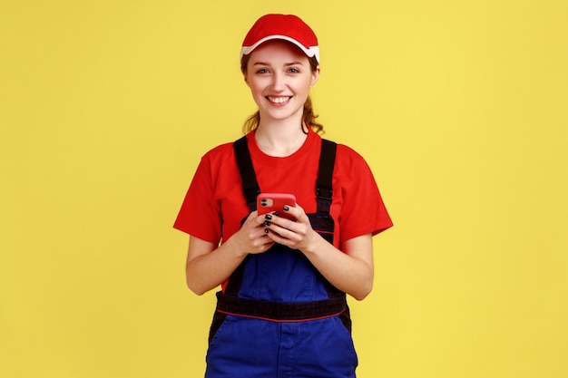 Mujer trabajadora que usa teléfono móvil para apoyar en línea la expresión de emociones positivas mirando a la cámara