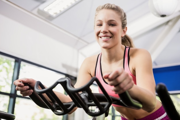 Mujer trabajando en bicicleta estática en clase de spinning