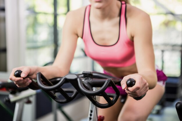 Mujer trabajando en bicicleta estática en clase de spinning