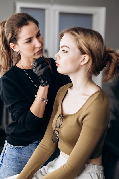 Foto una mujer está trabajando en la cara de una modelo.