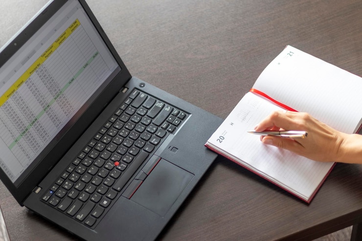 Foto mujer trabajando en la computadora portátil mostrando una hoja de excel en la pantalla con la tabla de amortización de préstamos bancarios