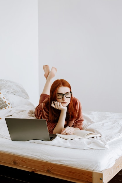 Foto una mujer está trabajando en una computadora portátil en su habitación en casa