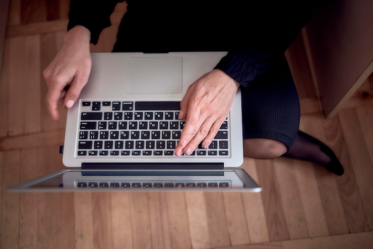 Foto mujer trabajando con una computadora portátil en el suelo