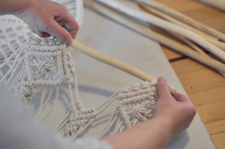 Foto mujer trabajando en una decoración de macramé personalizada con herramientas sobre un escritorio creativo visto desde arriba