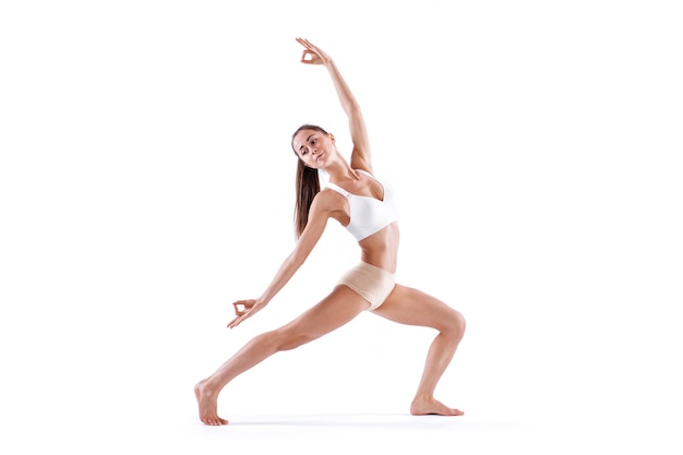 Mujer trabajando ejercicio de yoga, retrato de cuerpo entero, aislado en blanco. Equilibrio y meditación, armonía de cuerpo y mente.