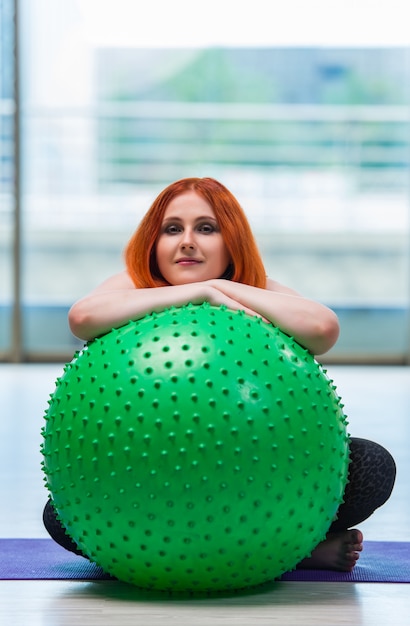 Mujer trabajando con pelota suiza en el estudio