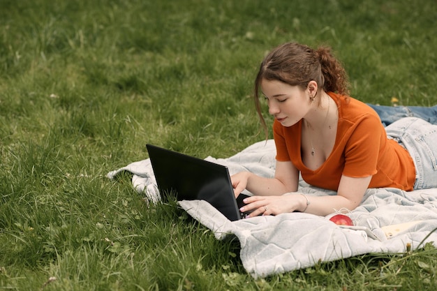 mujer, trabajo, con, computador portatil, en el parque