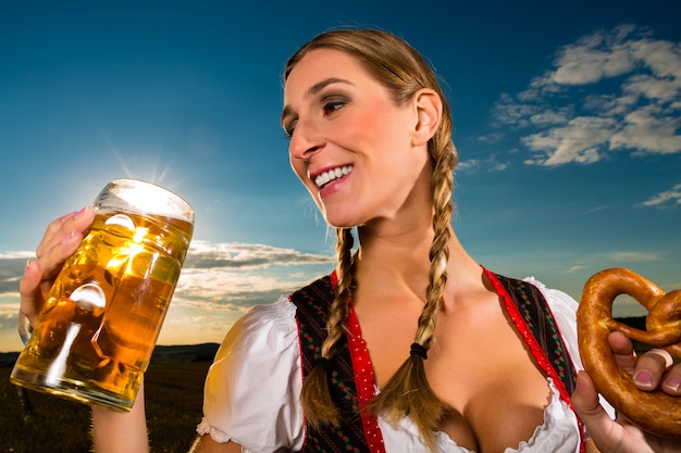 Foto mujer con tracht, cerveza y pretzel en baviera