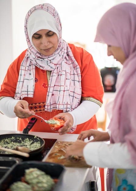 Mujer tradicional árabe musulmana en la cocina preparando la comida para el almuerzo