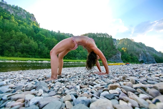 mujer, en, traje de baño, en, bancos, hacer, yoga