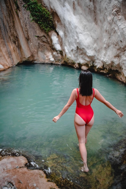 Mujer en traje de baño rojo Cascada de Dimosari en la isla Grecia de Lefkada