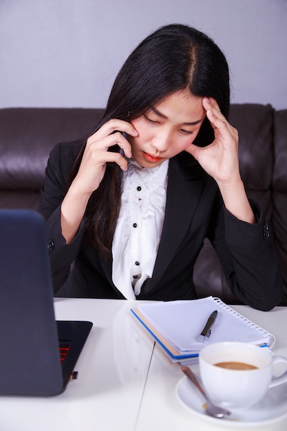 mujer en traje de negocios trabajando en el estrés desesperado hablando en el teléfono móvil