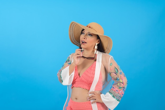 Mujer con traje de playa y gafas de sol con actitud positiva Retrato de estudio con fondo azul