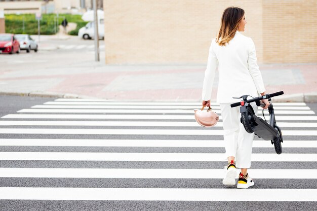 mujer en traje y scooter eléctrico