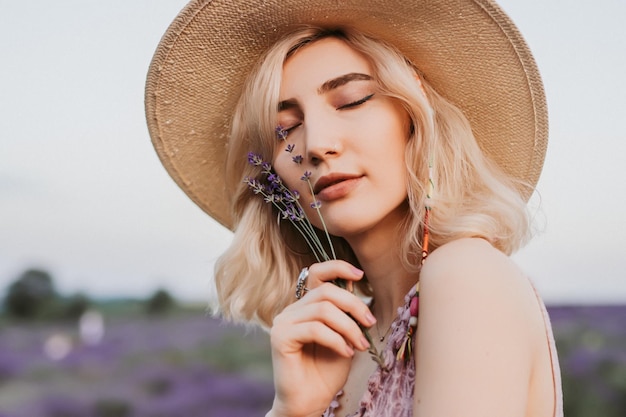 Mujer tranquila disfrutando de flores de lavanda