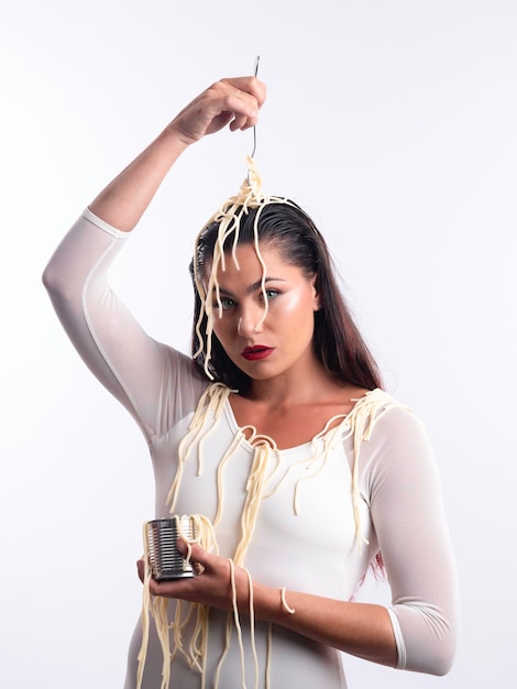 Mujer tranquila con fideos en la cabeza y lata en estudio