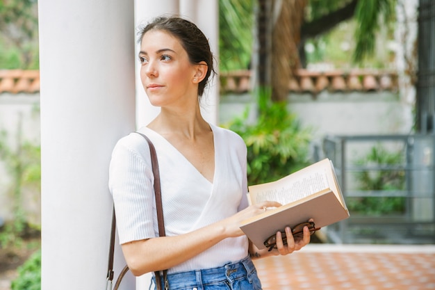 Mujer tranquila pensando en un libro que está leyendo