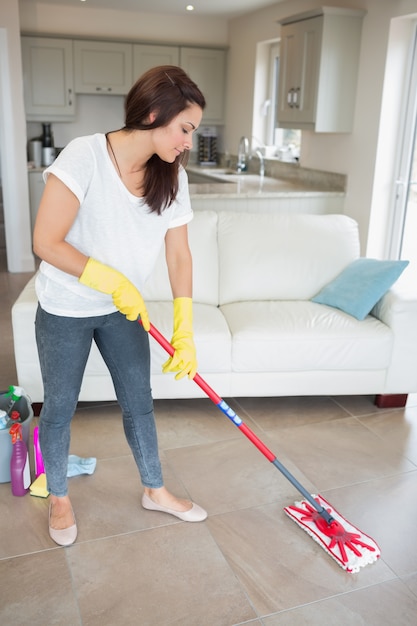 Mujer trapeando el piso de la sala de estar