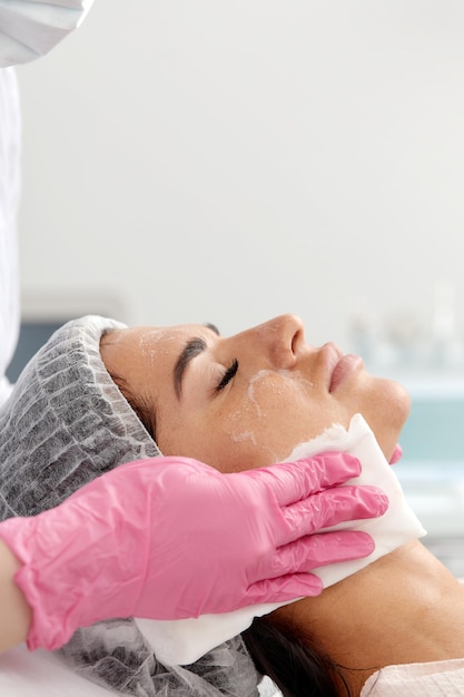 Mujer con tratamiento facial de limpieza en spa