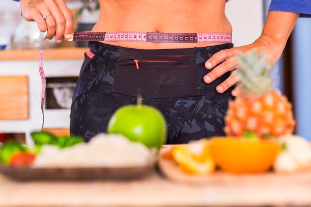 Mujer tratando de comer sano y saludable - línea de metro - sobre la mesa hay muchas frutas y verduras