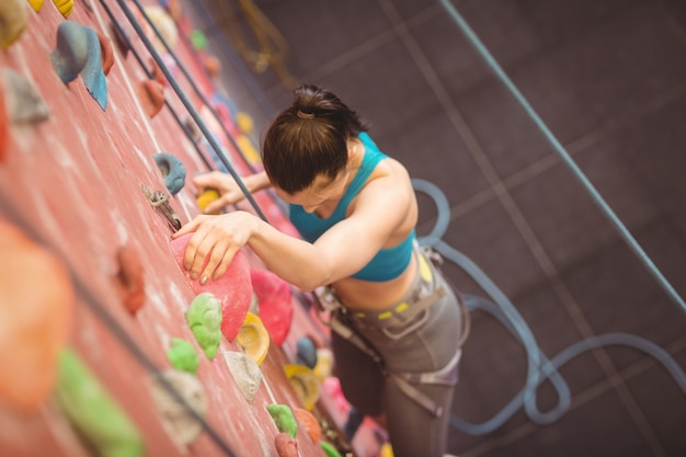 Foto mujer trepando por la pared de roca