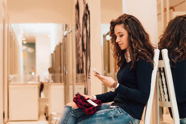 Mujer triguena hermosa en vestuario usando el teléfono.