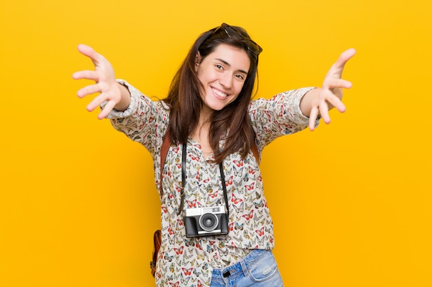 Foto la mujer triguena joven del viajero se siente confiada dando un abrazo a la cámara.