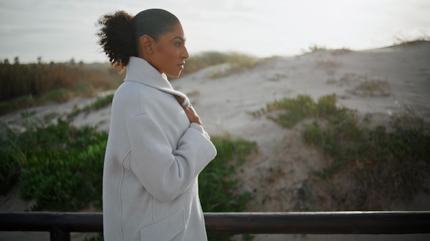 Mujer triste caminando en el muelle a la luz del sol de la mañana preocupada hermosa afroamericana