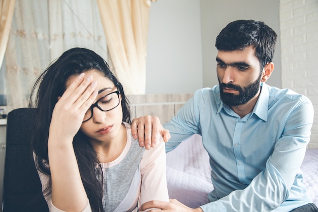 Mujer triste con hombre en casa