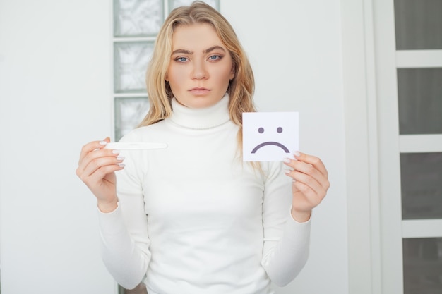 Mujer triste preocupada mirando una prueba de embarazo después del resultado.