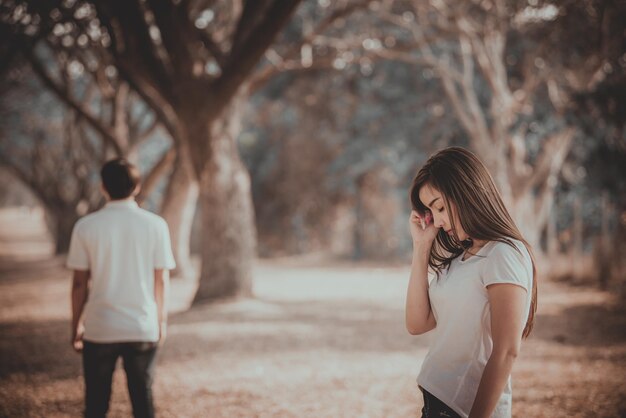 Mujer triste que mira a su novio caminando deja la vida su estilo vintage mujer angustiada concepto al aire libre