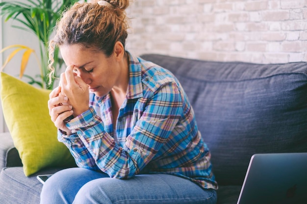 Foto mujer triste sentada en el sofá en casa