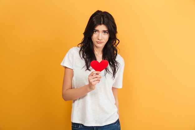 Foto mujer triste sosteniendo el corazón.