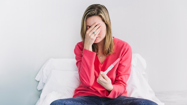Mujer triste con test de embarazo