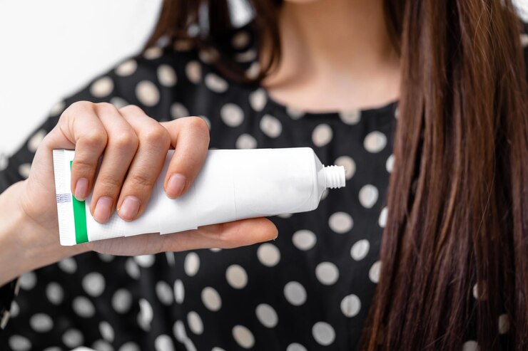 Foto una mujer con un tubo de pasta de dientes en la mano una mujer con un tubo de pasta de dientes preparándose para una sonrisa fresca y limpia