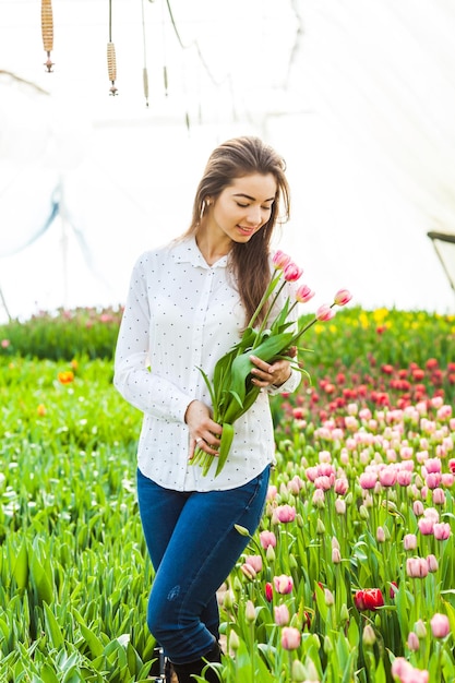 Mujer con tulipanes preparar flores para vender. Mercado de flores frescas