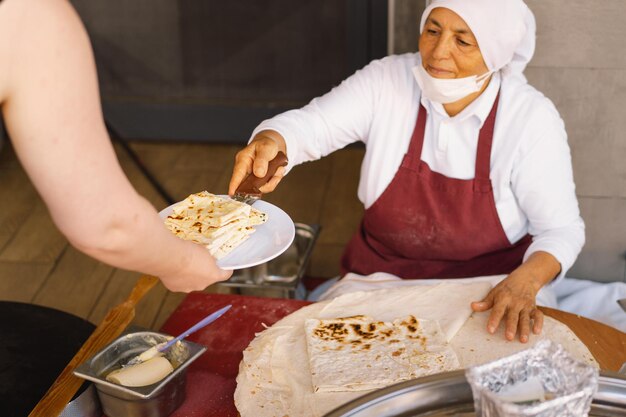 Mujer turca haciendo tortillas en una mesa rústica de madera