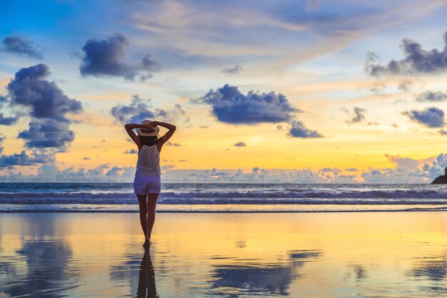 Mujer de turismo en la playa de Kata al atardecer