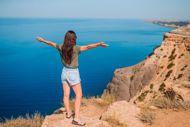 Mujer turista al aire libre en el borde de la orilla del acantilado